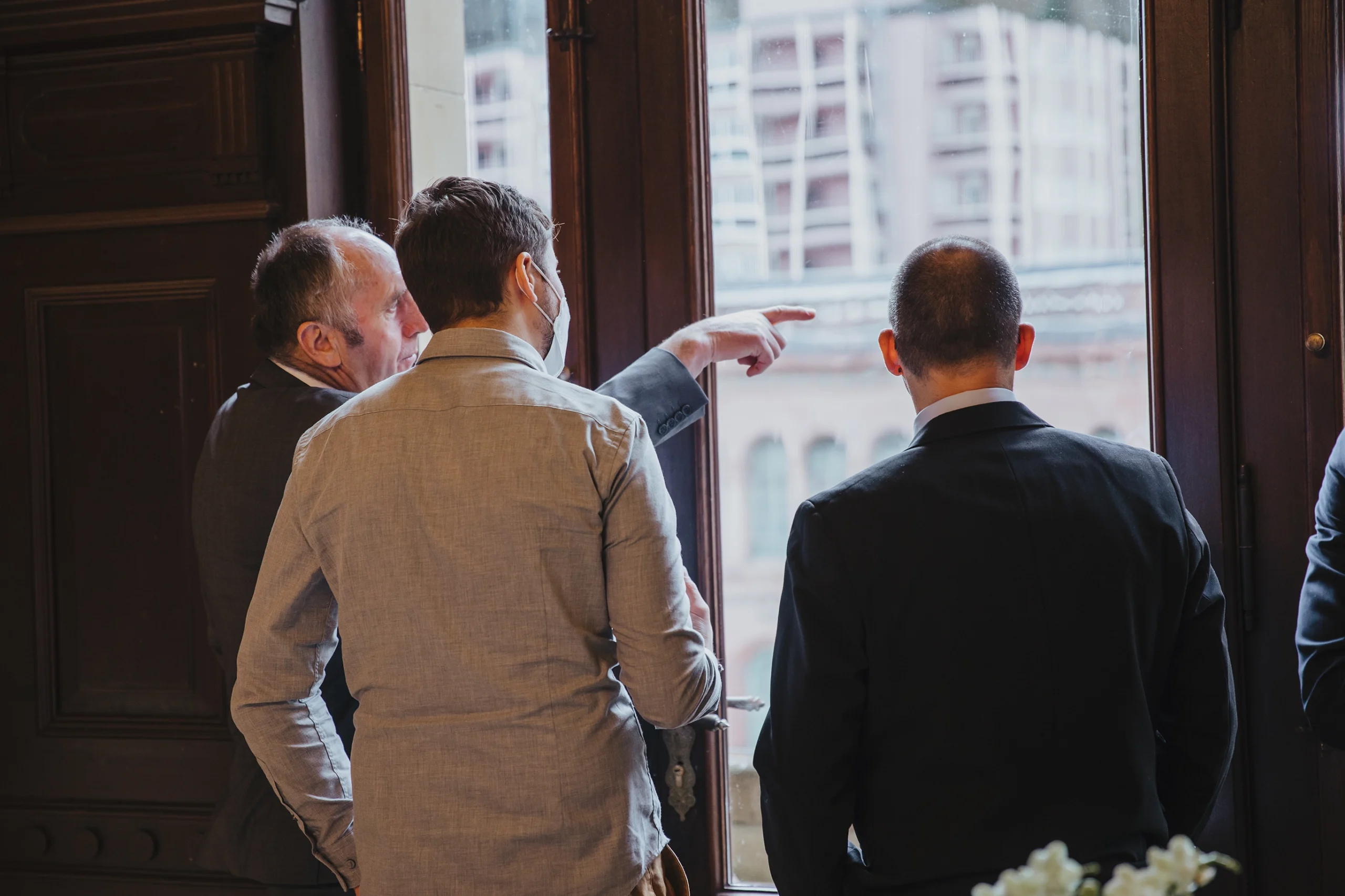 Drei Personen schauen aus dem Fenster